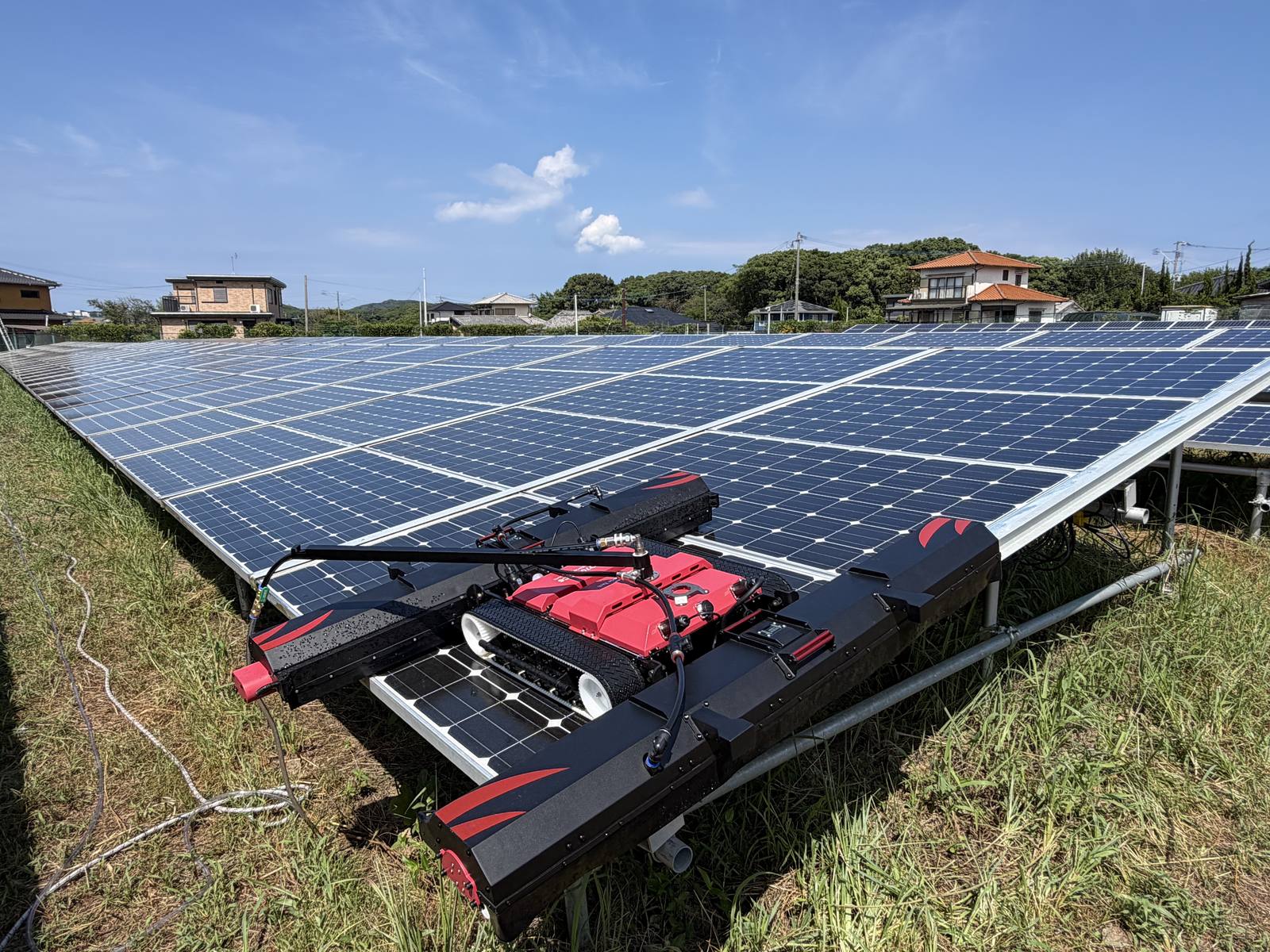 稼働中の太陽光発電所のアレイ上を走行するパネル洗浄ロボット RHINOSTAR・EC6